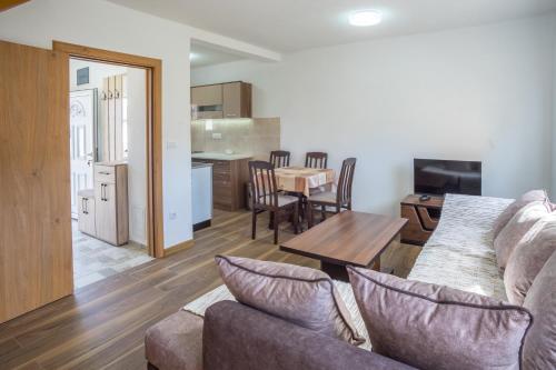 Una sala de estar y una cocina con un sofá y una mesa. en Dubljevic, en Žabljak