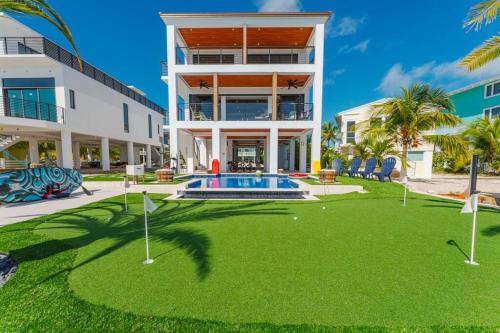 a large building with a yard with a pool and golf balls at Tavernier Ocean Vista in Tavernier