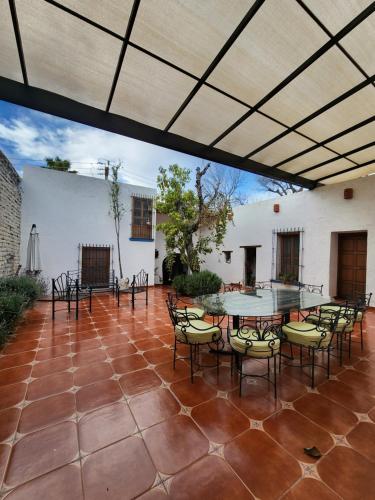 an outdoor patio with a table and chairs at Casa Orquídea con Alberca en Centro Histórico in Parras de la Fuente