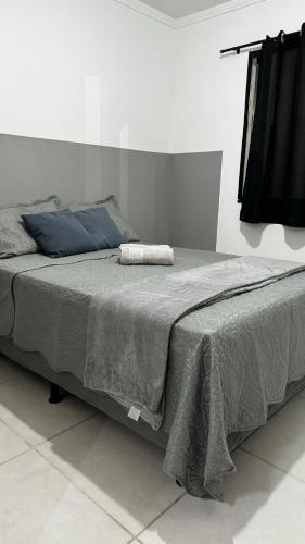 a large bed with a gray blanket on top of it at Standard Garden 02 in Caruaru