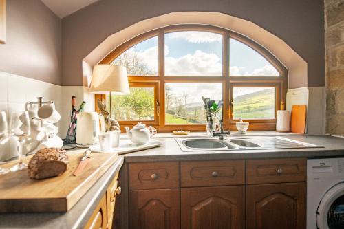uma cozinha com um lavatório e uma janela em The Arches em Westerdale