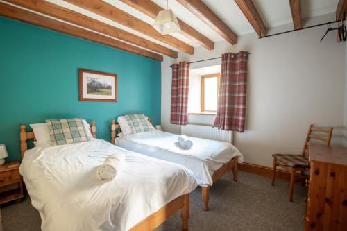 Duas camas num quarto com paredes azuis em The Arches em Westerdale