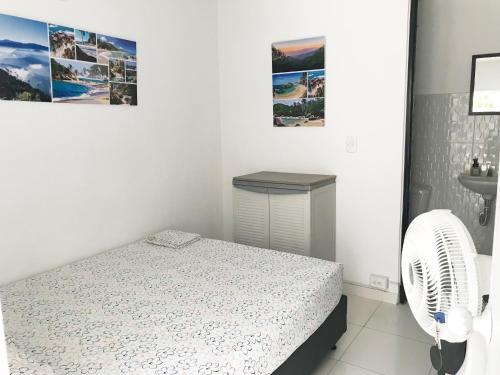 a white bedroom with a bed and a fan at Rest 1 in Santa Marta
