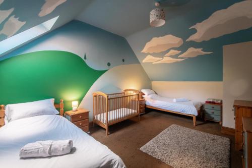 a bedroom with two beds and a cloud mural at The Old Cart House in Westerdale