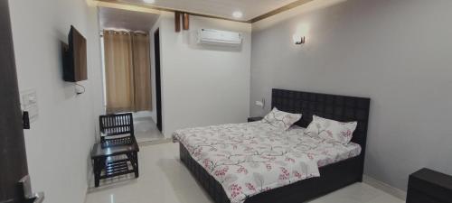 um quarto com uma cama e uma televisão na parede em Hotel Vinny em Jalandhar