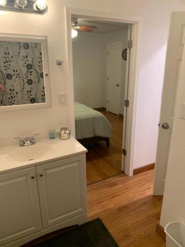 a bathroom with a sink and a mirror and a bed at Home in Malvern in Malvern