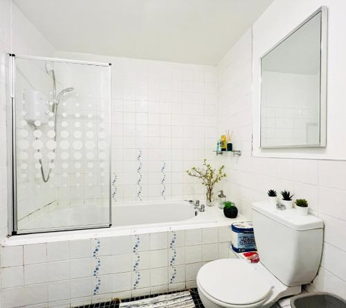 a white bathroom with a tub and a toilet at Beautiful & Spacious 2-Bed Flat in City Centre with Free Parking in Glasgow