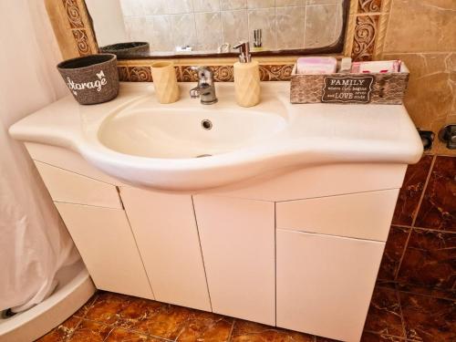 W łazience znajduje się biała umywalka i lustro. w obiekcie Kalogria Beach Apartments w mieście Kalogria