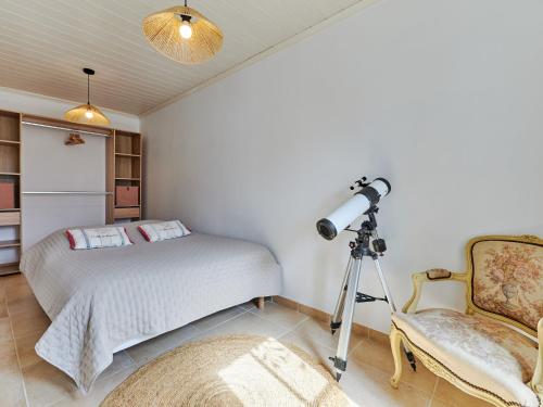 une chambre avec un lit, une caméra et une chaise dans l'établissement Holiday Home Le Hameau Boudet by Interhome, à Barneville-Carteret