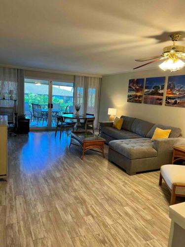 a living room with a couch and a table at Maui Bliss: 1BR Corner Haven, Ocean & Golf Views in Kahana