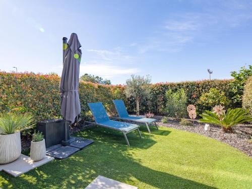 - un jardin avec 2 chaises et un parasol dans l'établissement Apartment Golfe Horizon-3 by Interhome, à Fréjus
