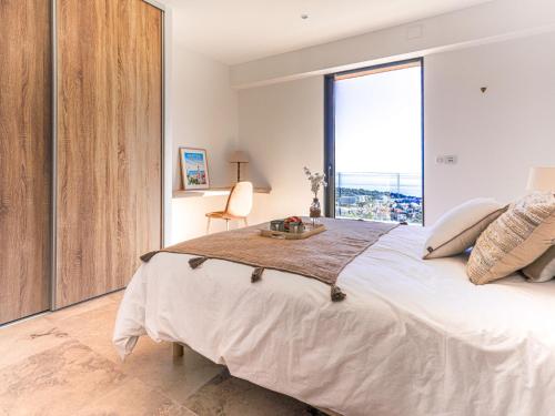 a bedroom with a large bed with a large window at Villa La Concorde by Interhome in Roquebrune-Cap-Martin