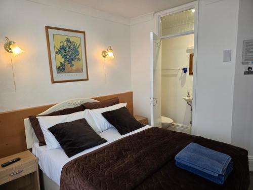 a bedroom with a large bed with brown and white pillows at The Fairhaven Hotel in Nottingham