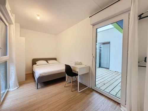 Un dormitorio con una cama y un escritorio y una ventana. en Le Martray - Spacieux - 4 chambres, en Rennes
