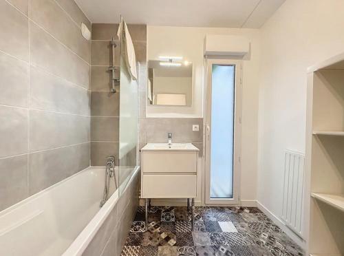 een witte badkamer met een wastafel, een bad en een wastafel bij Le Martray - Spacieux - Parking in Rennes