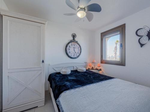 une chambre avec un lit et une horloge au mur dans l'établissement Apartment Front de Mer-25 by Interhome, au Barcarès