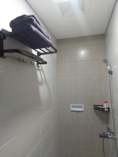 Comfy Studio with City View @BorneoBay Residence في Klandasan Kecil: حمام مع دش ودش من البلاط