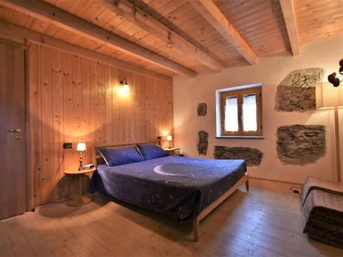 ein Schlafzimmer mit einem Bett in einem Zimmer mit Holzwänden in der Unterkunft Holiday Home Dubino Home by Interhome in Dubino