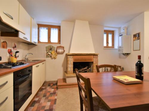 eine Küche und ein Esszimmer mit einem Tisch und einem Kamin in der Unterkunft Holiday Home Dubino Home by Interhome in Dubino