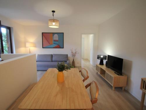 a living room with a table and a blue couch at Apartment Haridian by Interhome in Porto Valtravaglia