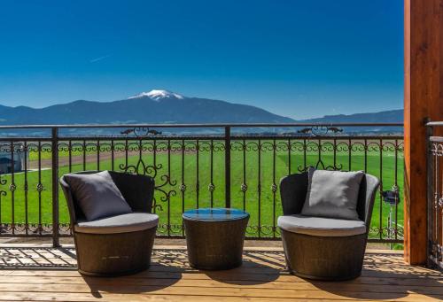 2 Stühle auf einer Terrasse mit Bergblick in der Unterkunft Hotel Restaurant Perschler in Rattenberg