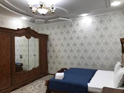 una camera con un letto e un grande specchio di Шербудин a Bukhara
