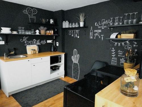 una cocina con paredes negras con dibujos blancos en la pared en Love Home en Horní Heršpice