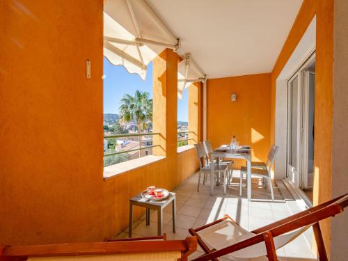 un balcon avec une table, des chaises et une fenêtre dans l'établissement Apartment Terre du Soleil-2 by Interhome, à Sainte-Maxime