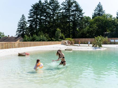 deux femmes jouant dans une piscine dans l'établissement Holiday Home Prestige 2 chambres 5 personnes by Interhome, à Payrac