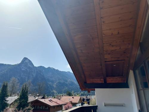 a balcony with a wooden ceiling with a view of mountains at Oberammergau, Fewo im gemütlichen Dachgeschoss in Oberammergau