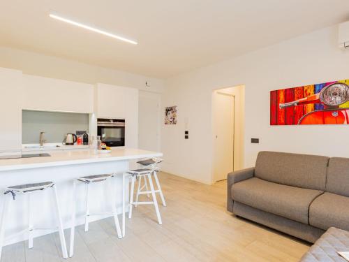 a kitchen and living room with a couch and a counter at Apartment Am See by Interhome in Riva del Garda