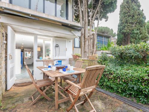 a wooden table and two chairs on a patio at Holiday Home Le Mandrie by Interhome in Punta Ala