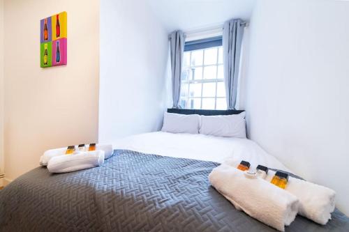 Beautiful one bedroom flat in Tavistock Place في لندن: غرفة نوم بسرير كبير مع وسادتين