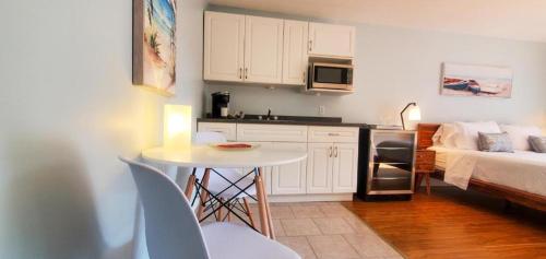 a small kitchen with a small table and a bed at Oasis by the Bay Vacation Suites in Wasaga Beach