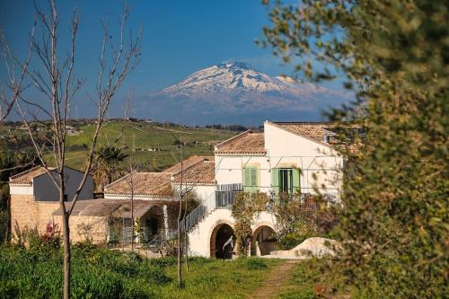 a house with a mountain in the background at Agriturismo Pietre di Gelo in Carlentini