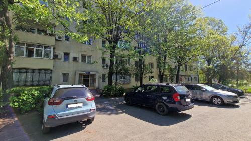 two cars parked in a parking lot in front of a building at MMT SweetHome 2 in Ploieşti