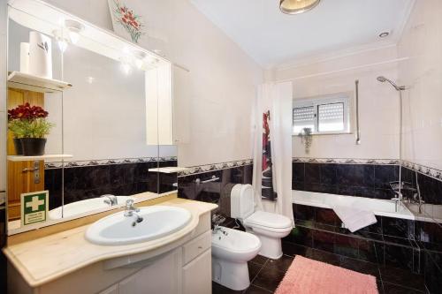 a white bathroom with a sink and a toilet at Villa da floresta in Arcos