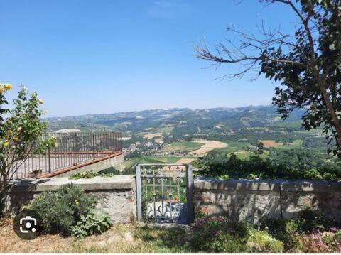 ein Tor in einer Steinmauer mit Blick auf ein Tal in der Unterkunft Cà Francesca in Diano dʼAlba