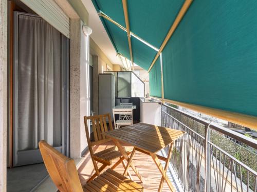 balcón con mesa de madera y 2 sillas en Apartment Borghouse by Interhome, en Borghetto Santo Spirito