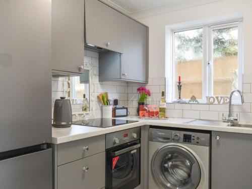 a kitchen with a washing machine and a sink at The Sashes - Cozy Apartment - FREE Parking - Ultrafast WIFI - Smart TV - Netflix - sleeps up to 6! Close to Poole Town Center & Sandbanks & Bournemouth in Poole