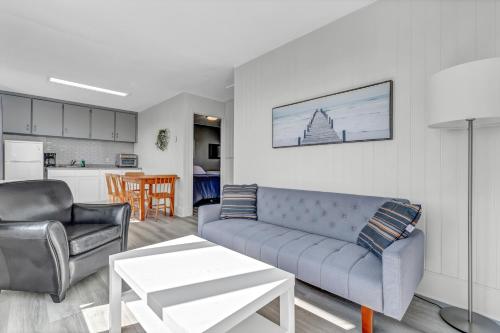 uma sala de estar com um sofá e uma mesa em Cape View Motel & Cottages em Mavillette