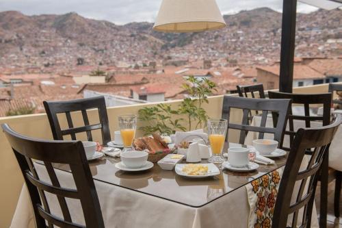 een tafel met eten en uitzicht op de stad bij Hotel Andean Host Inn in Cuzco