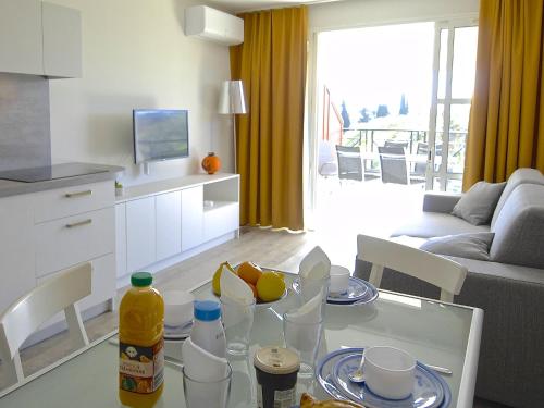 - un salon avec une table en verre et des fruits dans l'établissement Apartment Le Village - VJ 107 by Interhome, à Agay