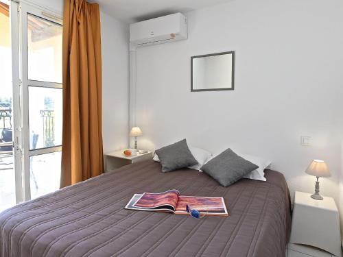 - une chambre avec un lit et un magazine dans l'établissement Apartment Le Village - VJ 107 by Interhome, à Agay