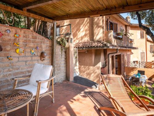 un patio con 2 sillas y una mesa y un edificio en Holiday Home Le Sughere by Interhome en Porto Ercole