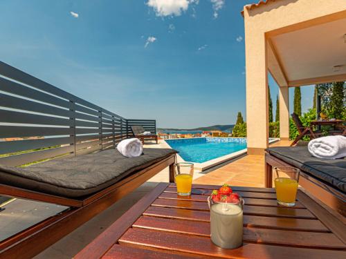 Un patio con una mesa con dos vasos de jugo de naranja. en Holiday Home Paola by Interhome, en Brodarica