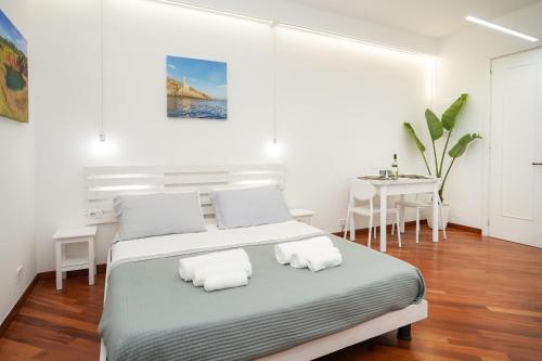 una camera bianca con letto e tavolo di Due metri sopra al mare a Otranto