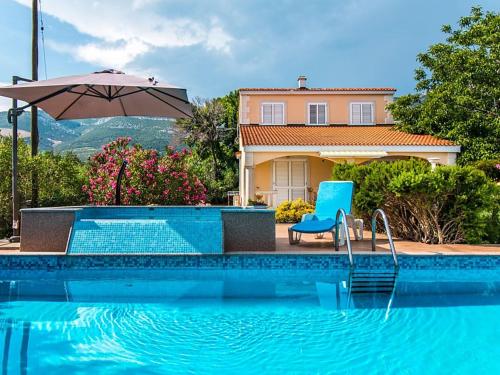 uma piscina com uma cadeira azul e um guarda-sol em Holiday Home Marija by Interhome em Kaštel Novi