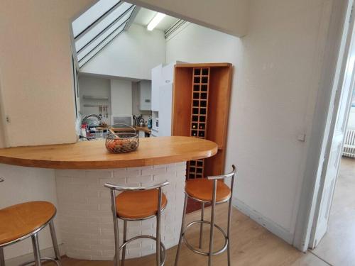 - une cuisine avec deux tabourets et un comptoir dans une pièce dans l'établissement Grand T3 sur quai vue St-clair, à Sète