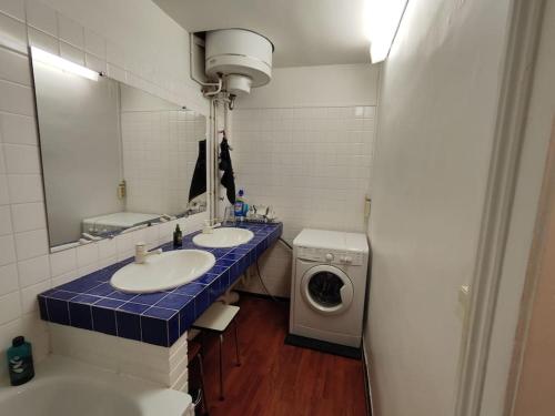 une salle de bain avec deux lavabos et une machine à laver dans l'établissement Grand T3 sur quai vue St-clair, à Sète